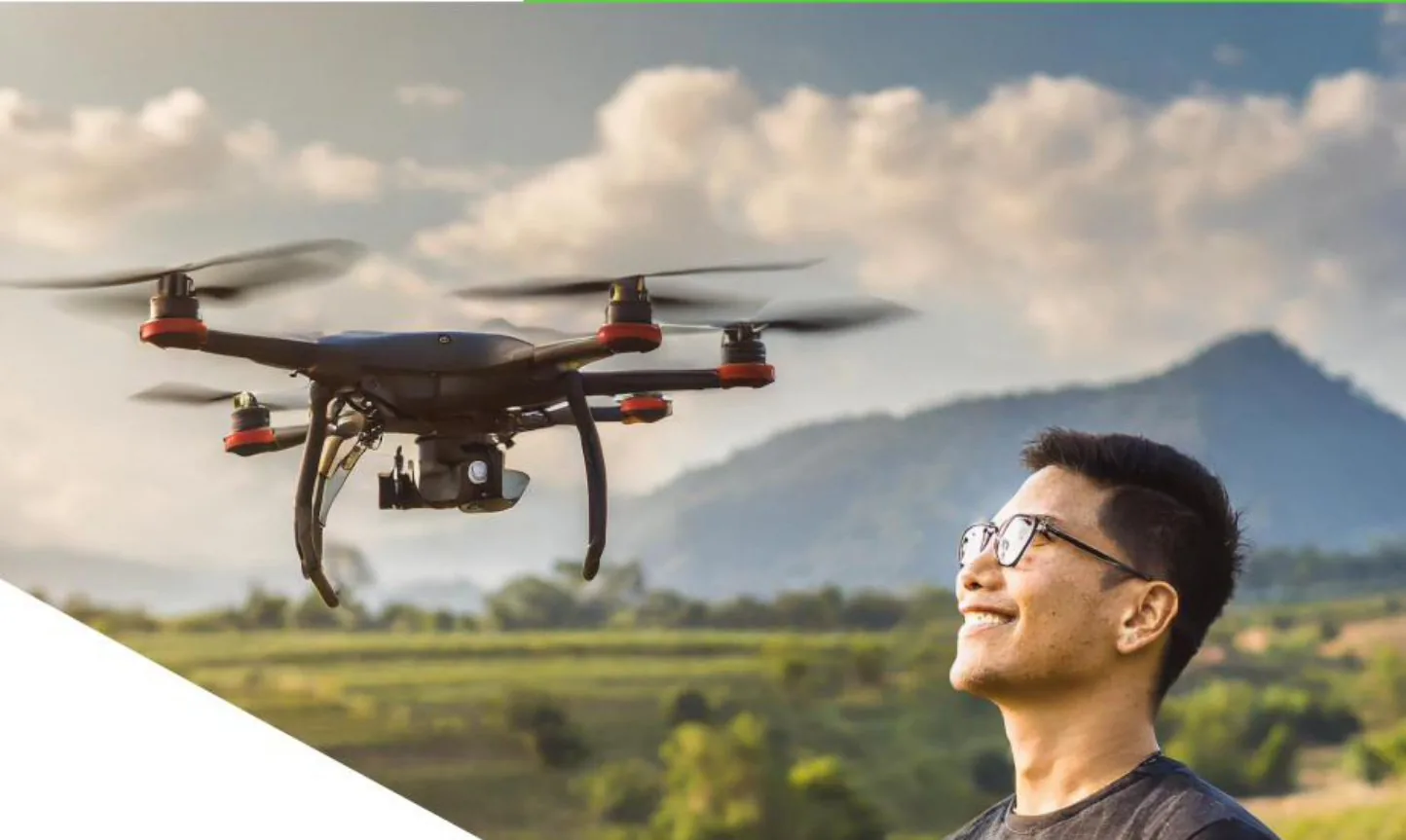 Operator pre-flighting a Theta spray drone over standing crop
